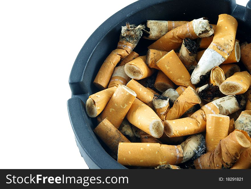Cigarette butts in ashtray over white surface