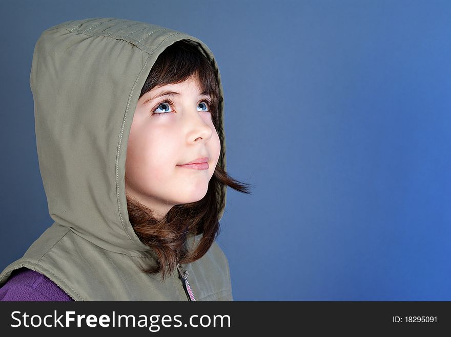 Smiling little child looking up at copyspace isolated on blue background