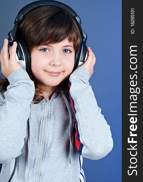 Cute little girl with earphones isolated on blue