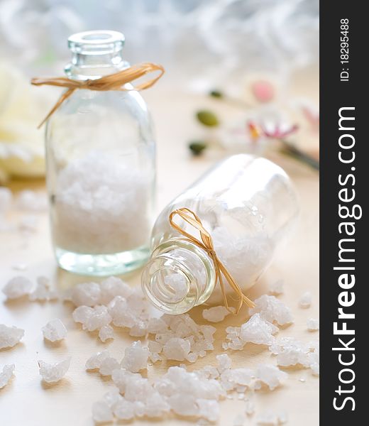 Jar of sea salt and flower on wood