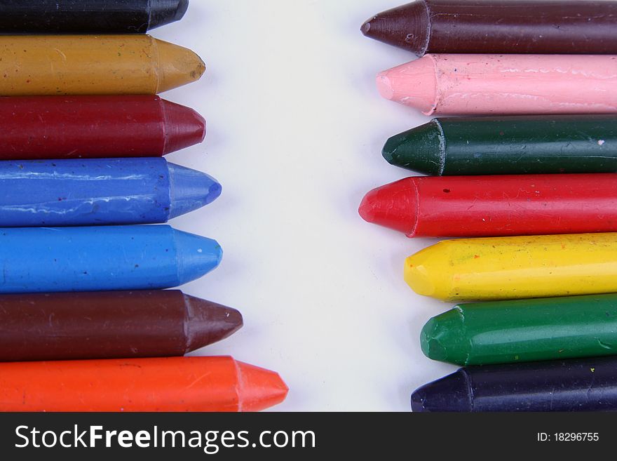 many colored crayons over white background