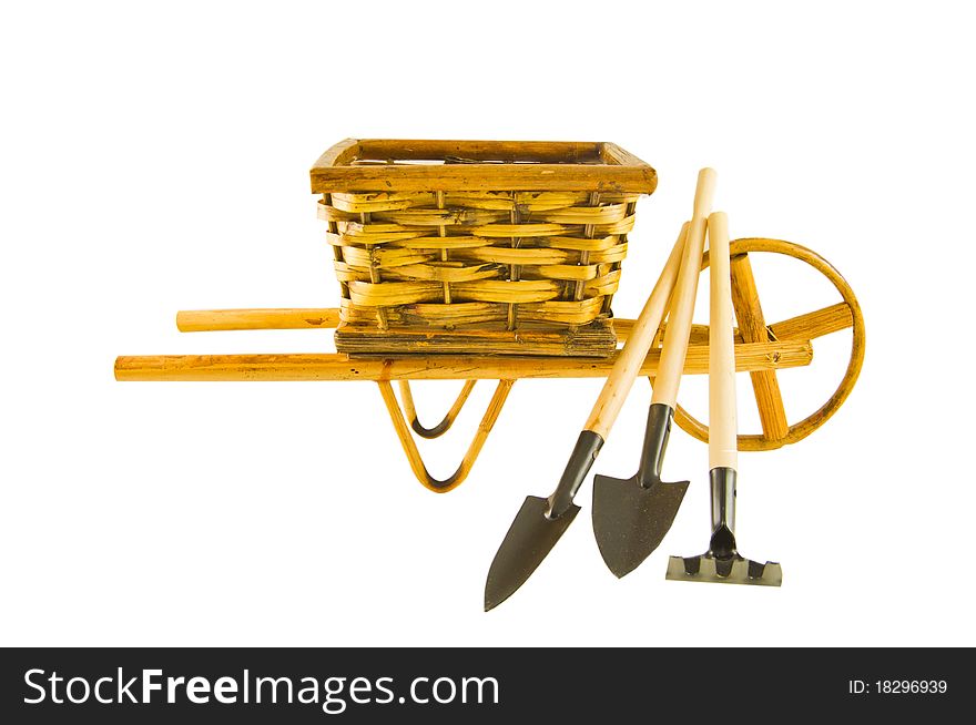 The cart with rake, shovel and spade isolated over white. The cart with rake, shovel and spade isolated over white