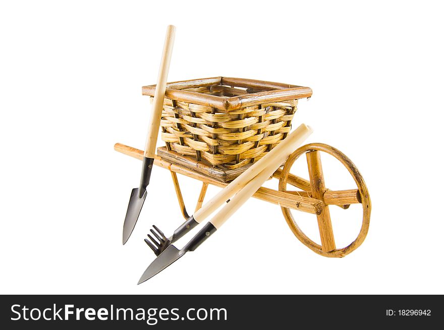 The cart with rake, shovel and spade isolated over white. The cart with rake, shovel and spade isolated over white