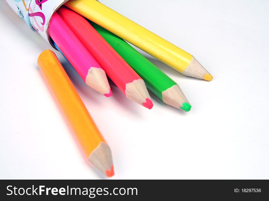 Vspread colored pencils over white background
