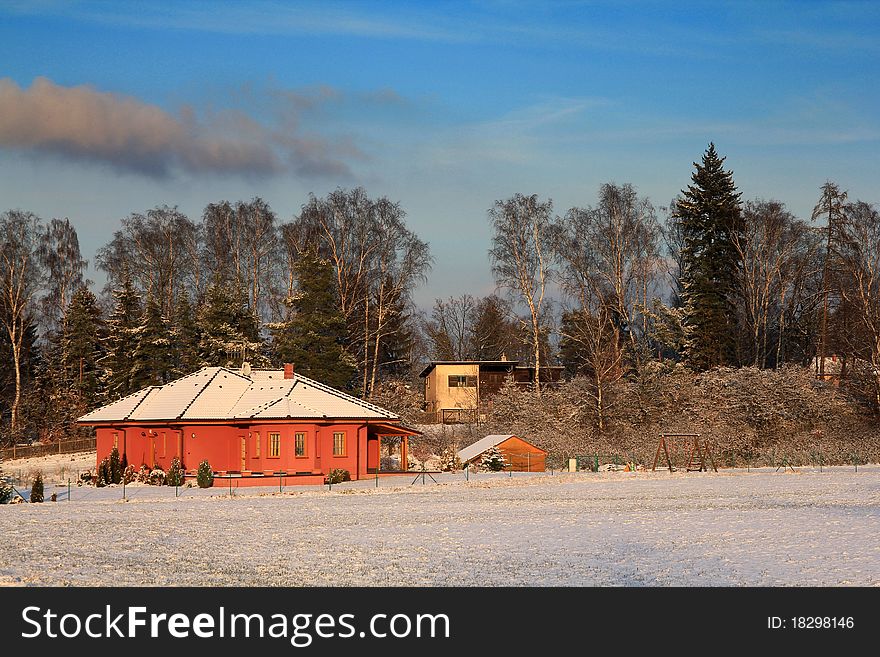 Winter house landscape under a blue sky with clouds. Winter house landscape under a blue sky with clouds