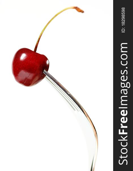 One fork with one red cherry. One fork with one red cherry