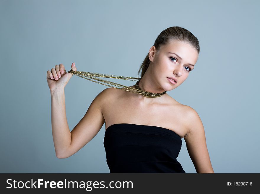 Beautiful woman pulling gold necklace. Beautiful woman pulling gold necklace