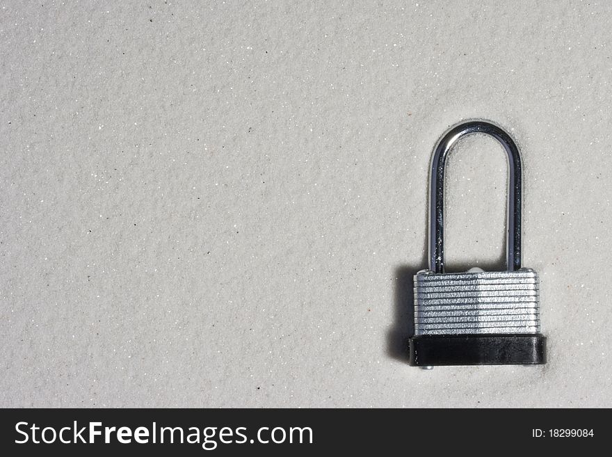 Metal lock isolated on a background of sand.