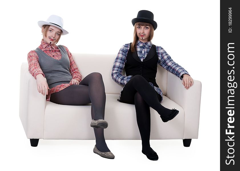 Two girls on the couch with a mustache painted on a white background