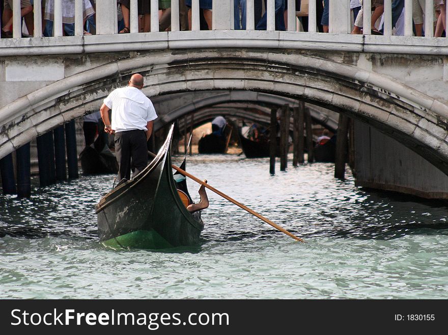 Gondolier rowing in a canal of Venice - Italy