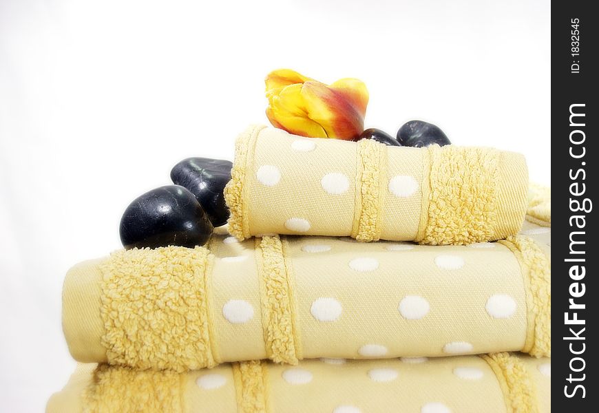 A pile of bath towels on white background and flowers