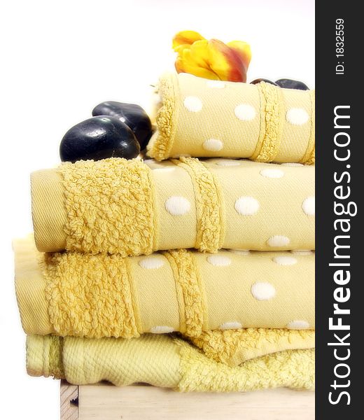 A pile of bath towels on white background and flowers