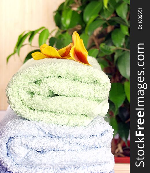 A pile of bath towels on bambu background and flowers