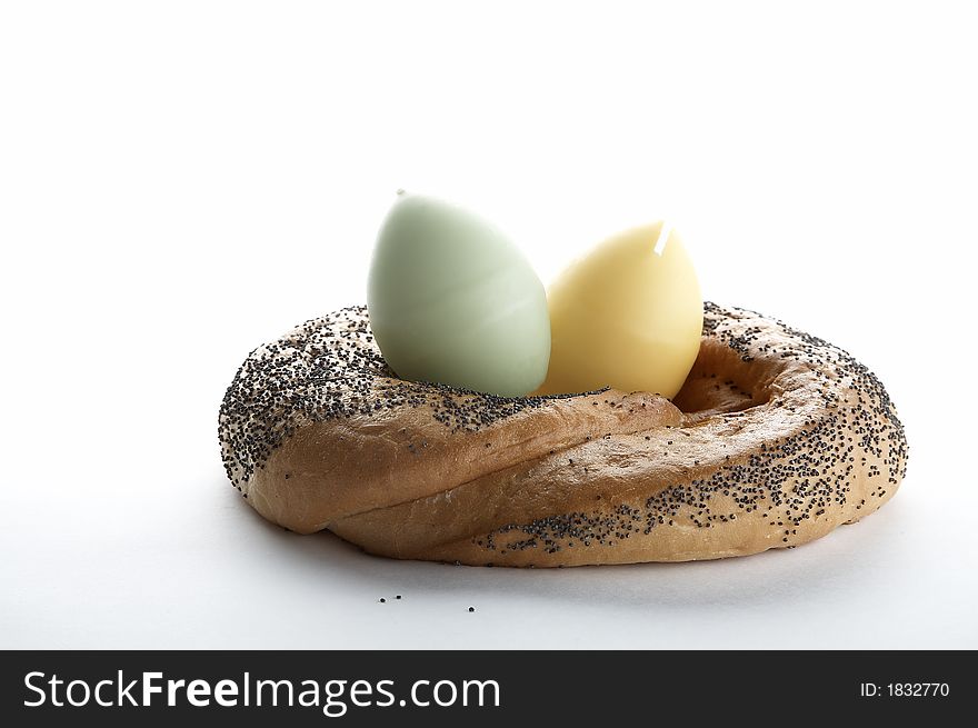 Egg shaped candles in bagel like easter nest on white background. Egg shaped candles in bagel like easter nest on white background