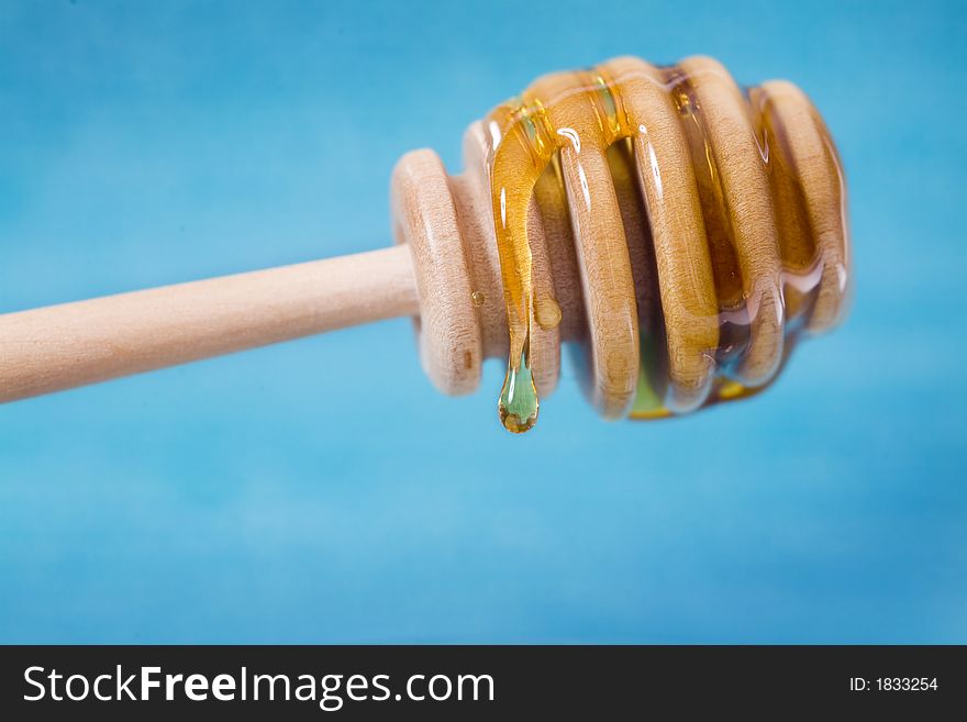 Wooden honey dipper coated in delicious honey