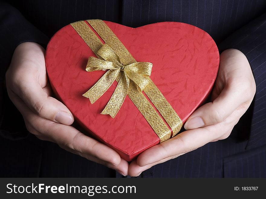Both hand holding a heart shape gift box. Both hand holding a heart shape gift box.
