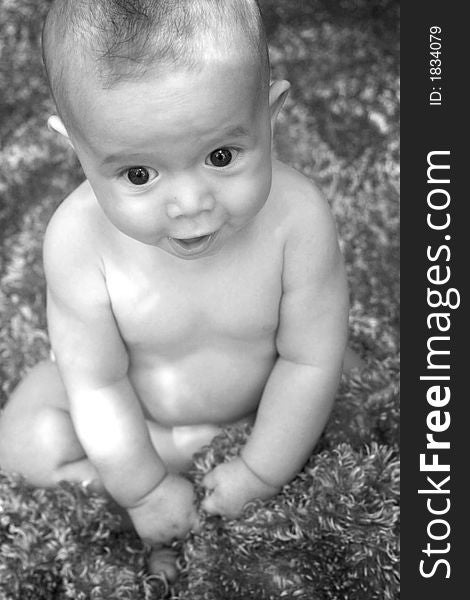 Image of smiling baby boy sitting on a fuzzy blanket