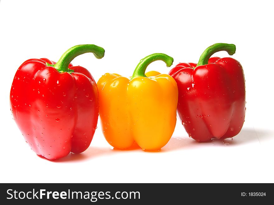 Excellent red and yellow peppers the covered drops of water on a white background
