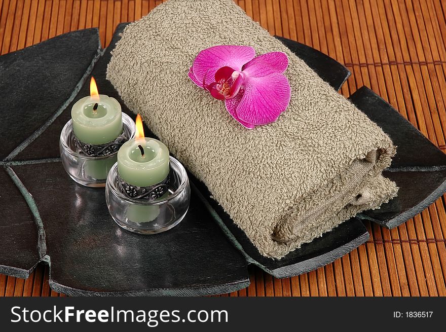 Orchid, candles, and towel on bamboo. Orchid, candles, and towel on bamboo