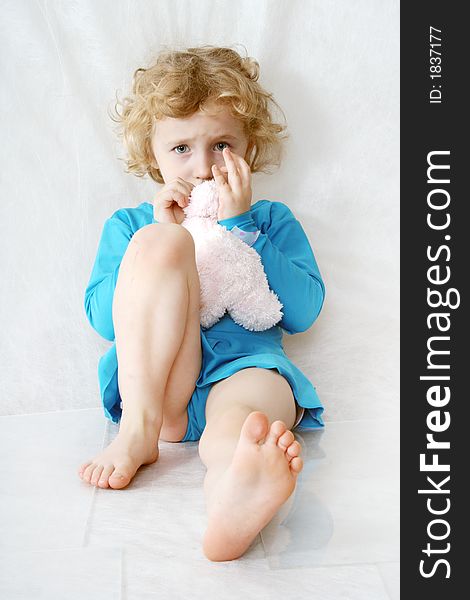 Little blonde curly girl with toy on the white with toy. Little blonde curly girl with toy on the white with toy