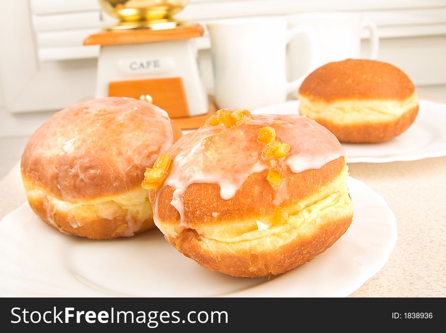 A tasty icing donuts on the plate in the kitchen. A tasty icing donuts on the plate in the kitchen.
