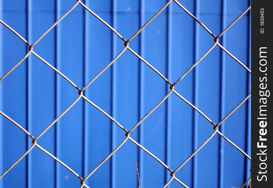 Blue metallic wall and grey metallic wire. Blue metallic wall and grey metallic wire