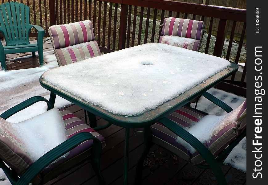 Photo of snow on patio furniture on a outside deck in the winter