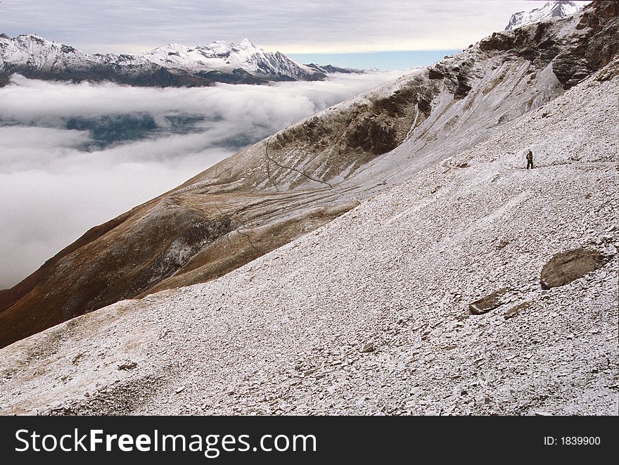 Hiker on the Eiger Trail after first Fall snowfall, The Eiger near Eiger Gletscher, Switzerland