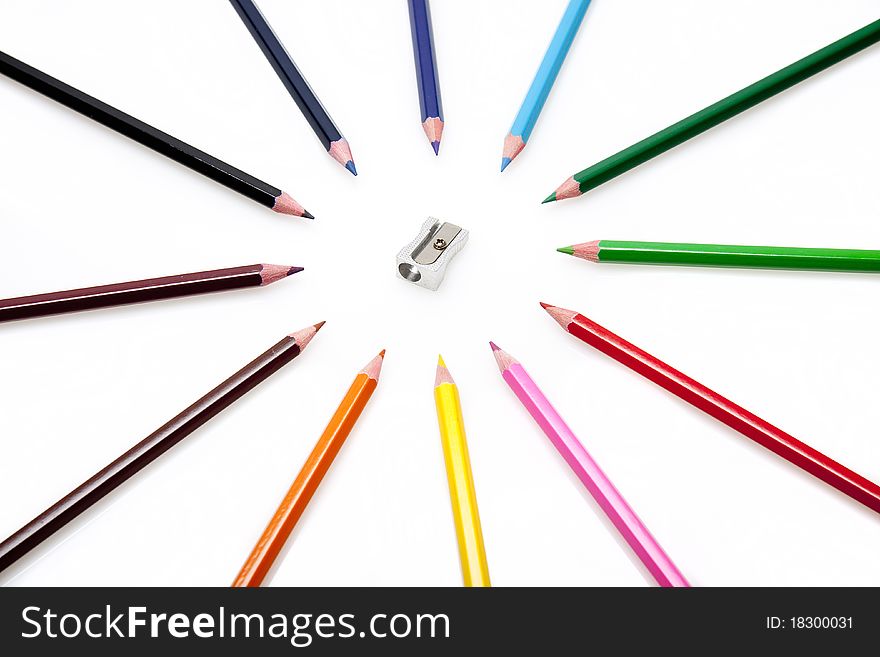 A group of colourful pencils surrounding a metal pencil sharpner. A group of colourful pencils surrounding a metal pencil sharpner.