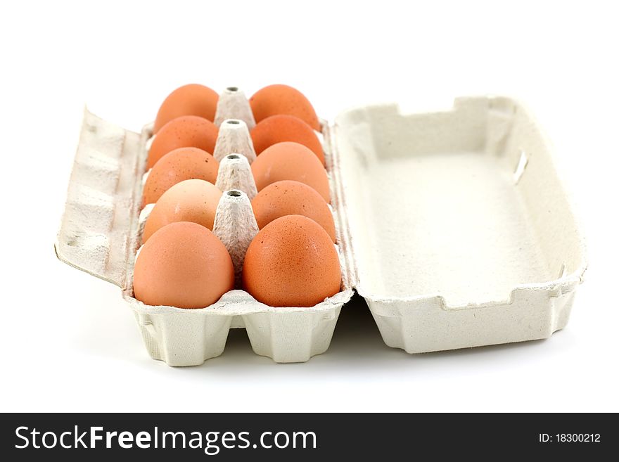 Ten chicken eggs in the box on white background