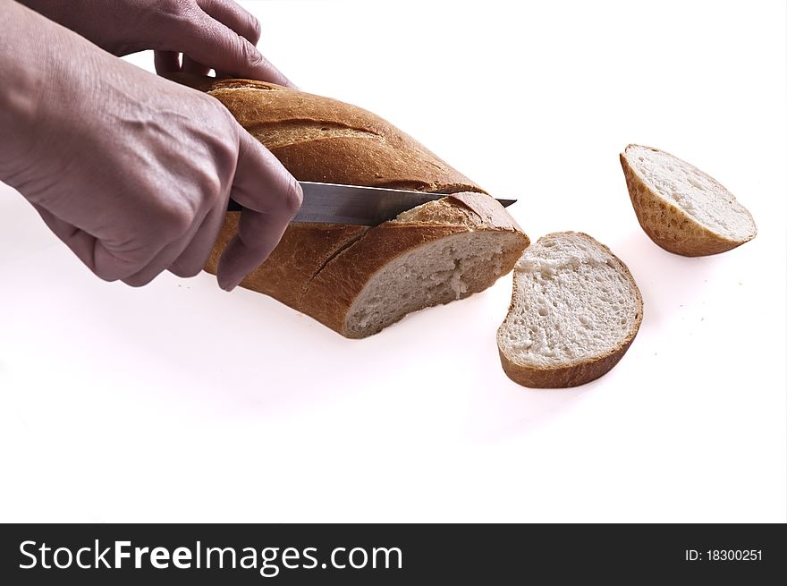 Cutting of a grain long loaf on a light background. Cutting of a grain long loaf on a light background