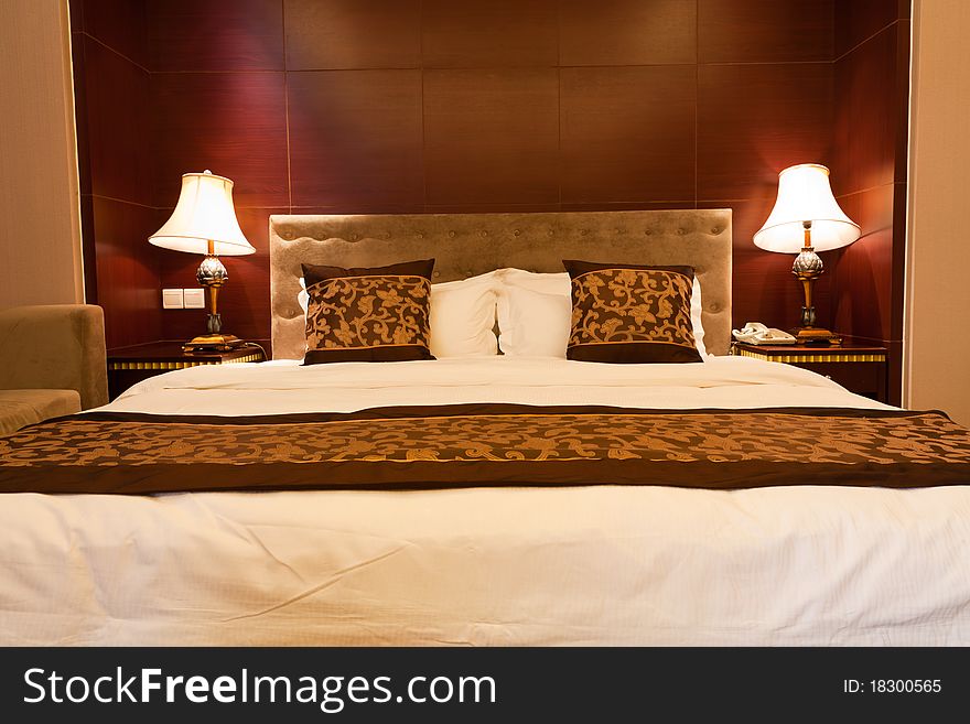 Hotel bedroom with kingsized bed and lamps.