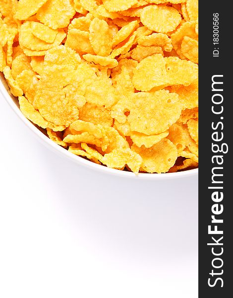 Bowl of cornflakes over white. Top view