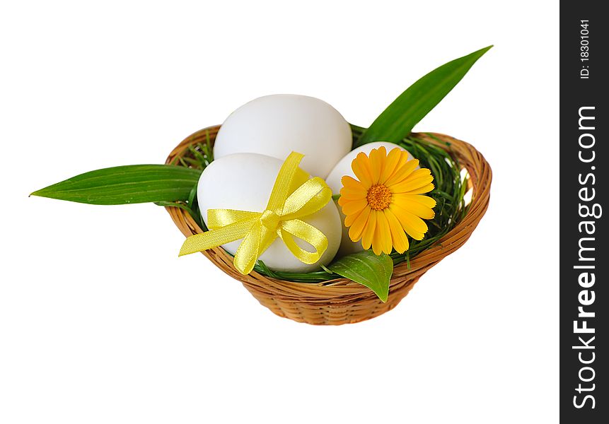 Easter eggs in basket with flower on white background