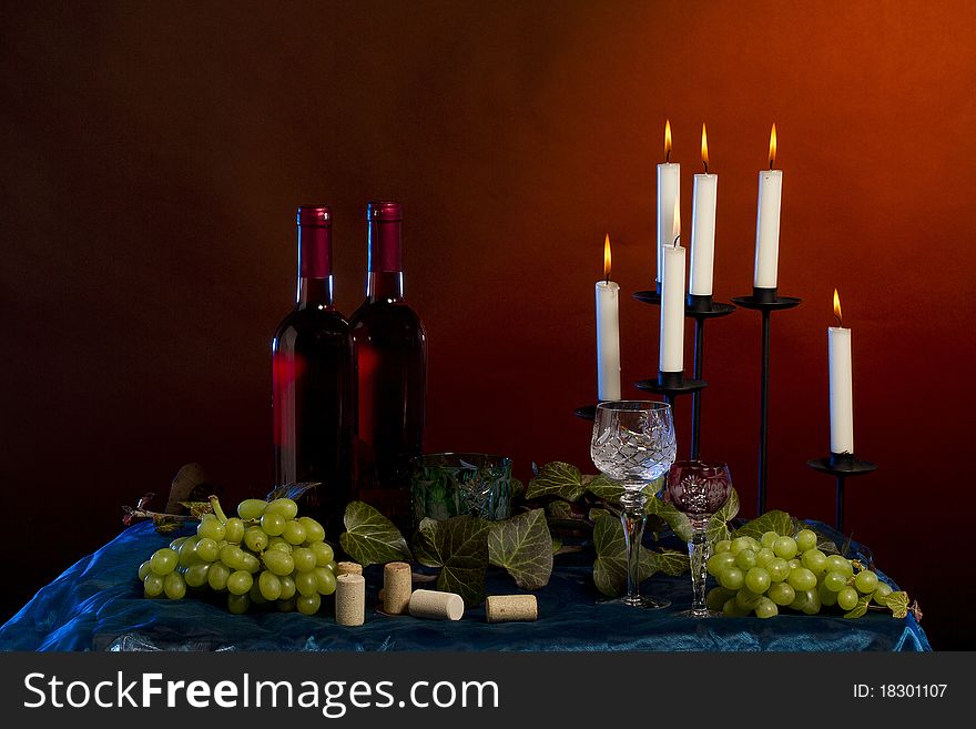 Arrangement of  wine bottle, glass, grapes, vine plant, corks  in studio. Arrangement of  wine bottle, glass, grapes, vine plant, corks  in studio