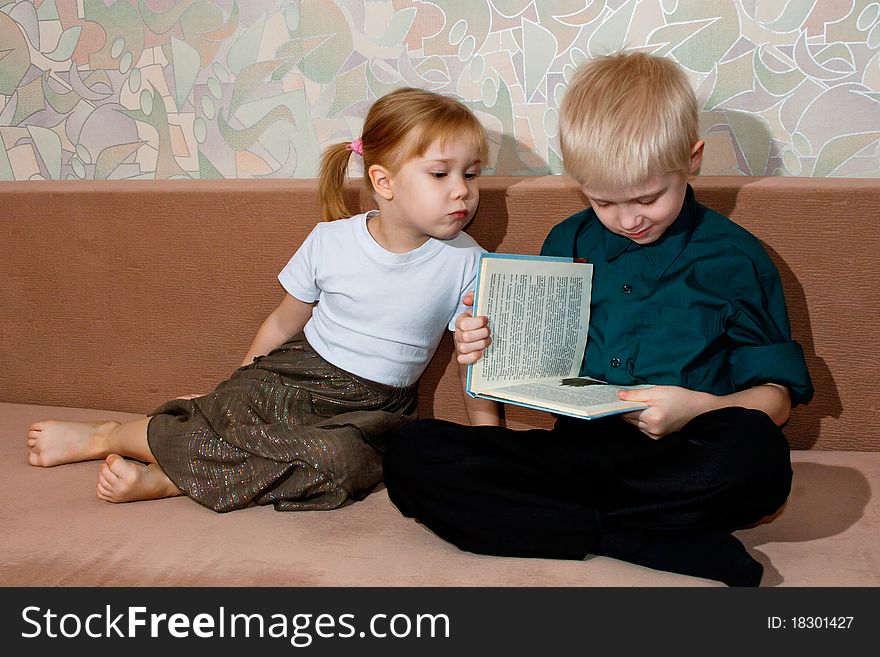 Brother and sister read a book together. Brother and sister read a book together
