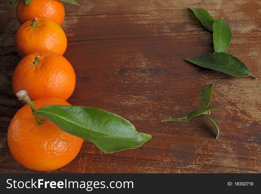 Mandarins and the leaves on a wooden table. Mandarins and the leaves on a wooden table