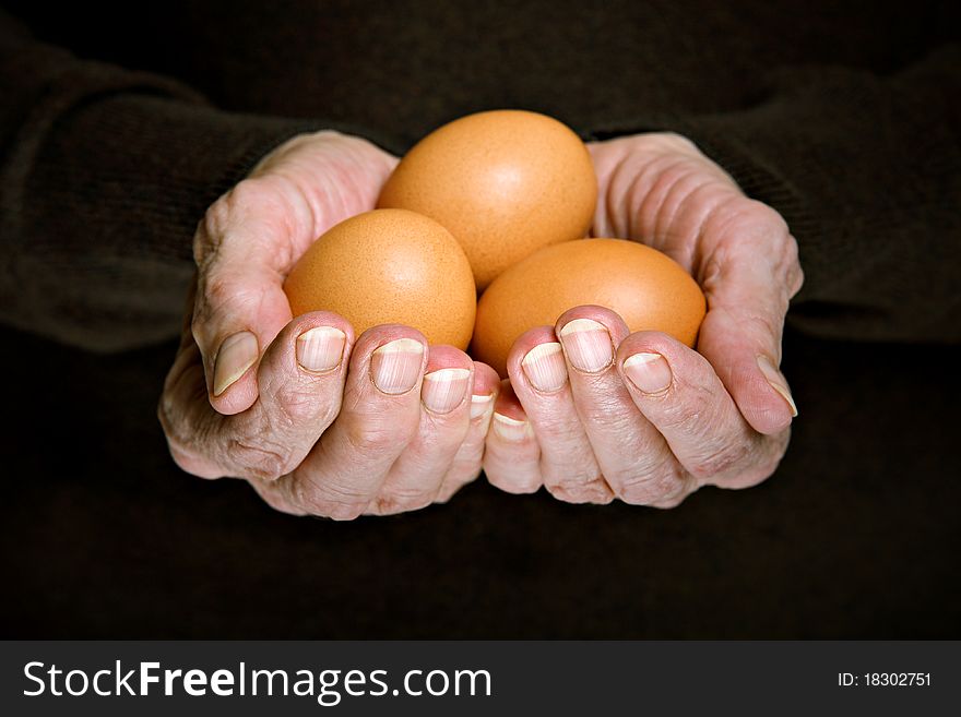 Three eggs in senior woman's hands
