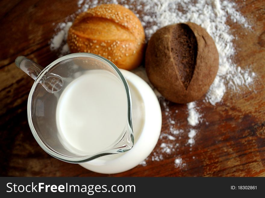 Milk, rye and wheat bread on a wooden table. Milk, rye and wheat bread on a wooden table