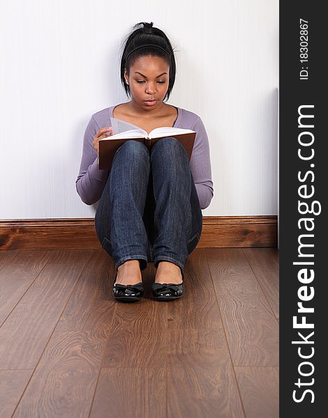 Young black girl concentrating hard reading a book