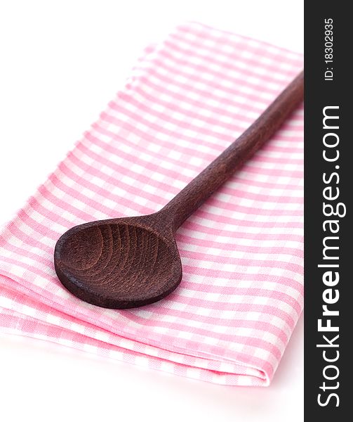 Wooden spoon on dishtowel isolated on white background