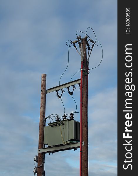 Two wooden poles with a green box and cables branching out to other electrical apparatus. Two wooden poles with a green box and cables branching out to other electrical apparatus.