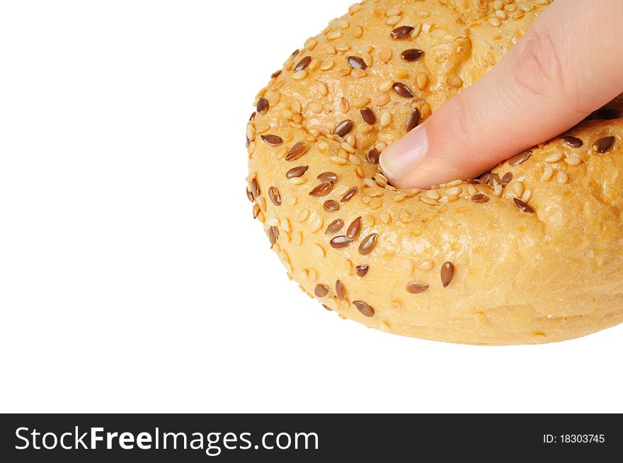 Bun, topped with sesame seeds pressed with finger. Isolated on white.