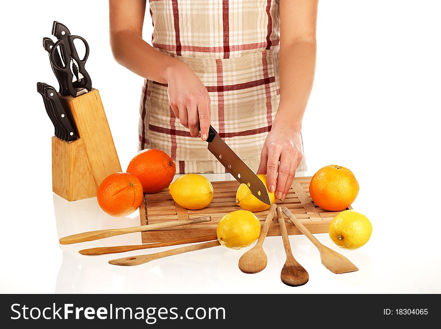 Girl cutting lemons with the knife, on a wooden plate. Girl cutting lemons with the knife, on a wooden plate