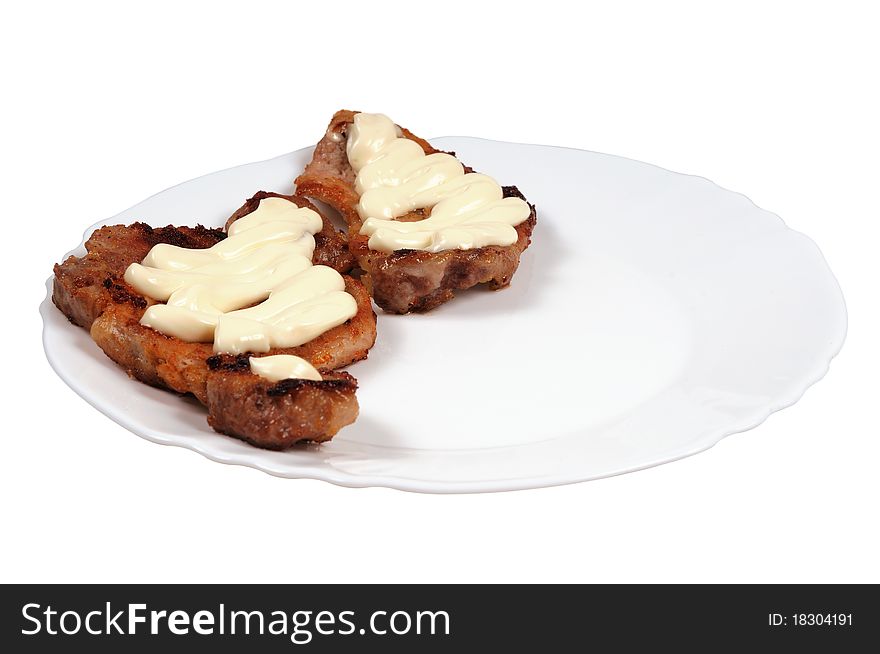 Grilled meat  with  mayonnaise  on a plate. Isolated on white.