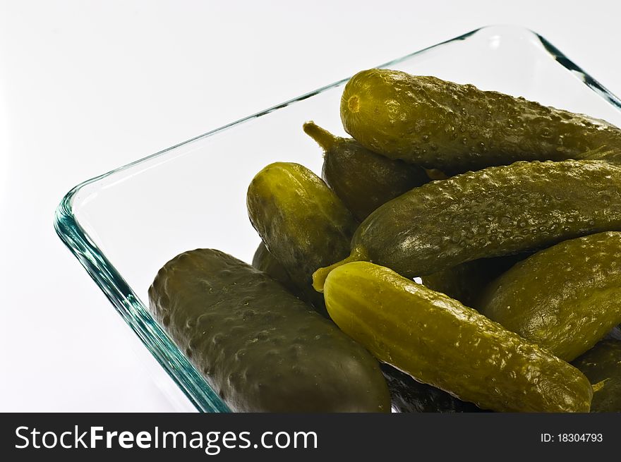 Pickled cucumbers in glass container on white background