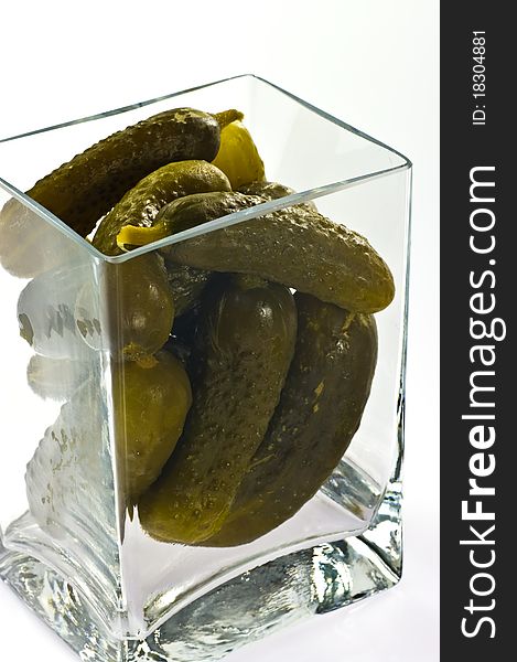 Pickled cucumbers in glass container on white background
