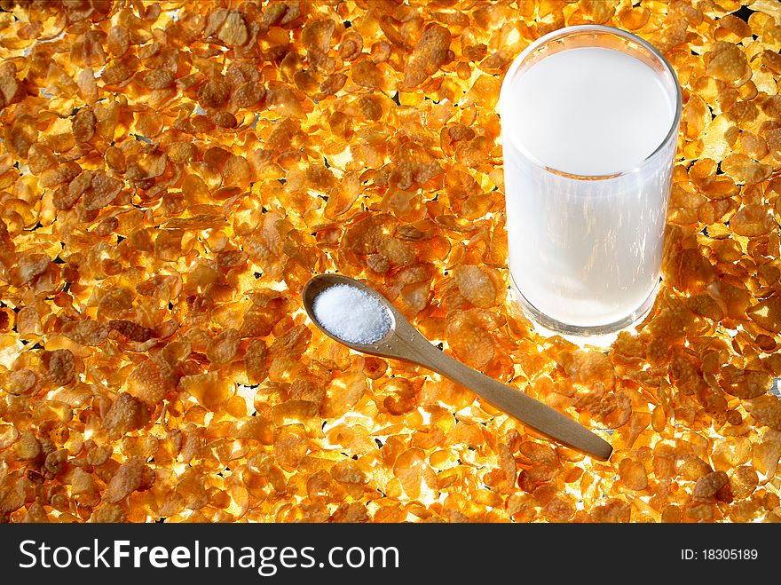 Corn Flakes with glass of milk and spoon of sugar