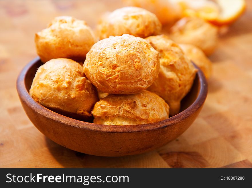 Freshly made cheese gougÃ¨res on wood cutting board