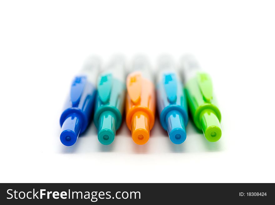Colorful markers lines up on a white background
